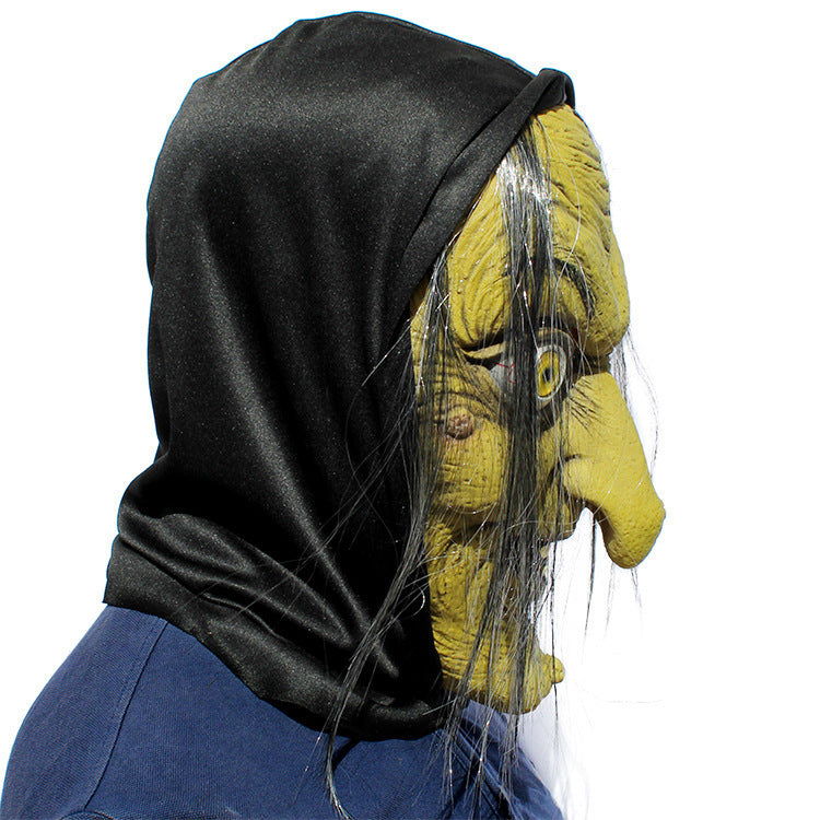 Latex witch mask side profile — dramatic hooked nose silhouette with black hood and trailing grey hair